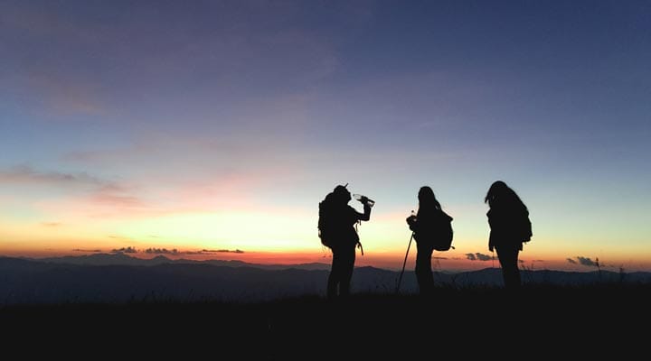 About Us Silhouetted Hikers At Sunset
