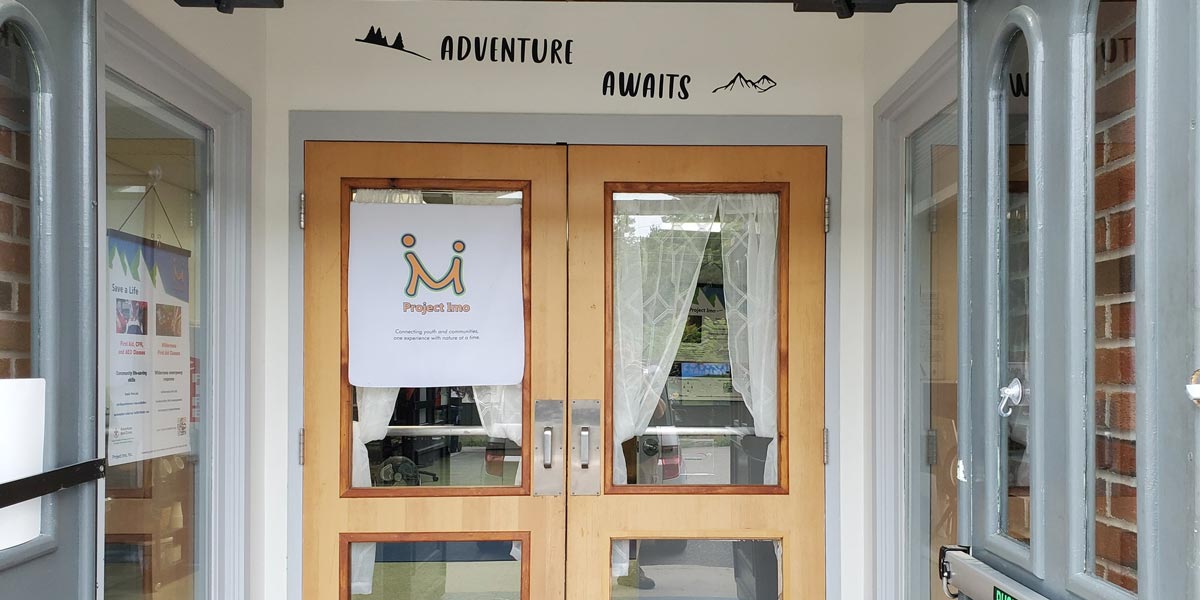 Front Doors of Project Imo that Says Adventure Awaits above it